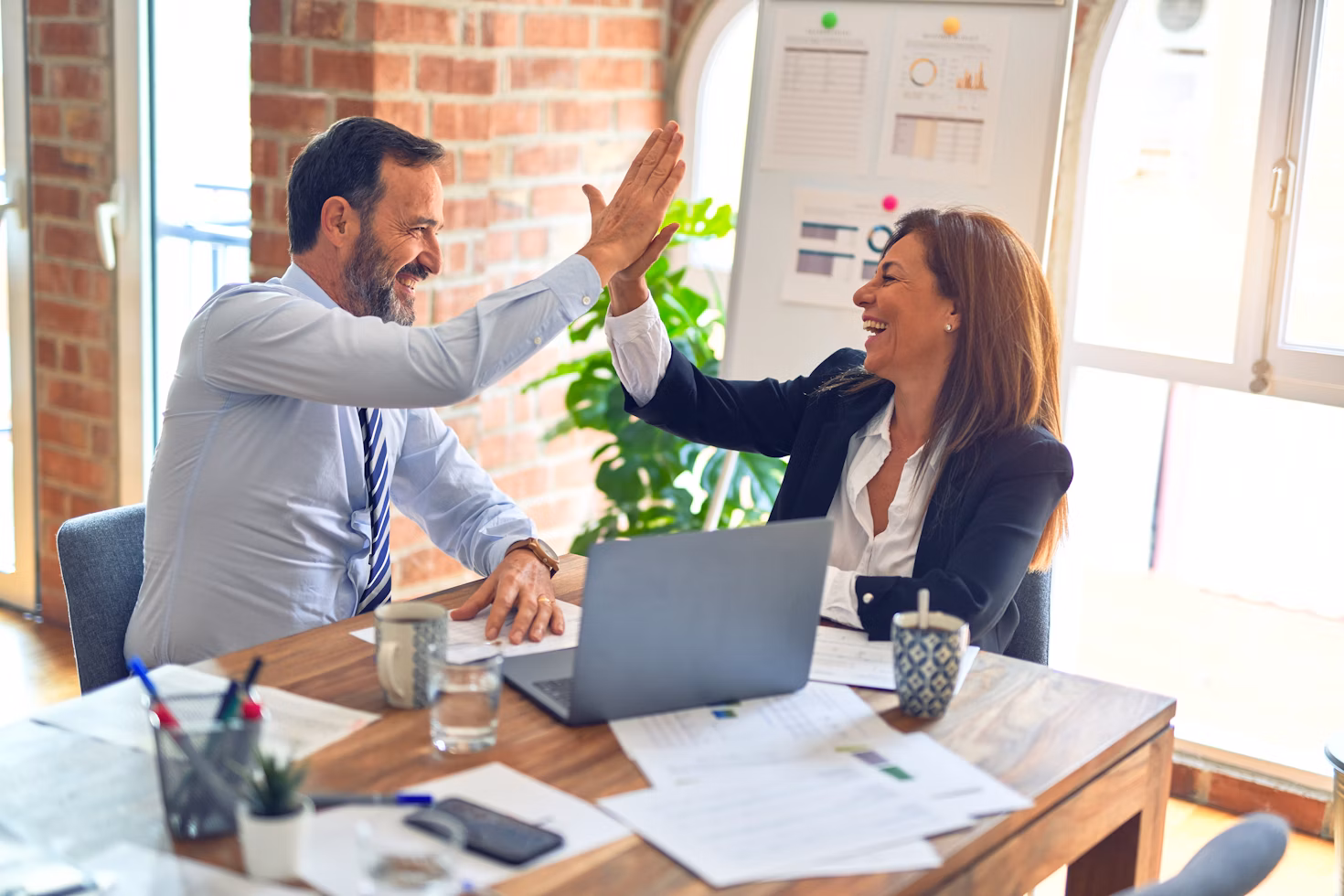 Sales team shaking hands celebrating success